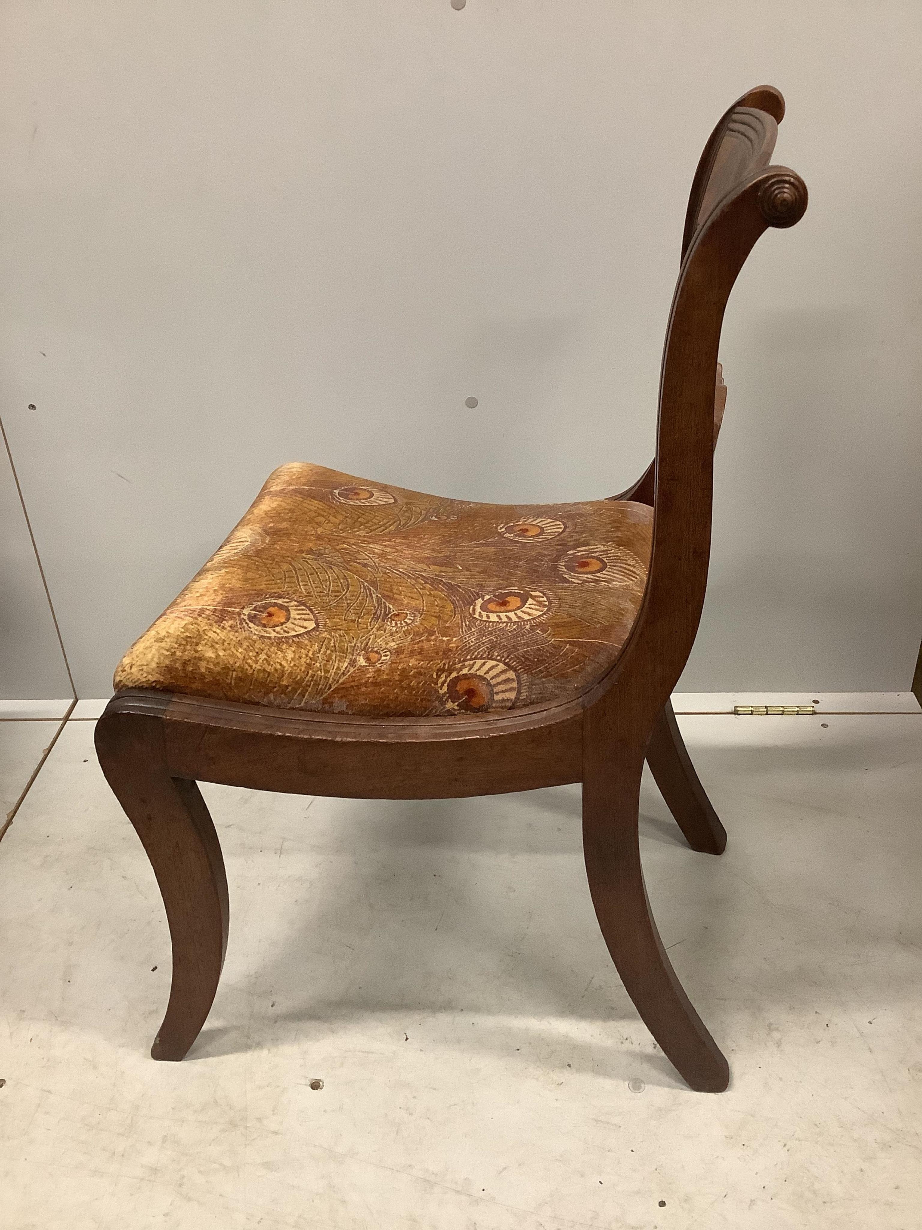 A set of four Regency mahogany dining chairs with sabre legs and roundel spars. Condition - poor to fair